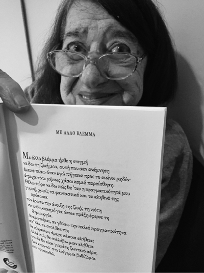 The poet holding up the poem 'With Other Eyes' for the translator last summer.